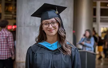 A happy graduate poses at the commencement venue