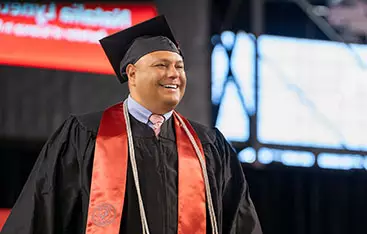 A happy nursing graduate walks at commencement