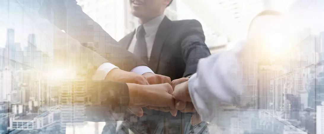 Graphic depicting business people bumping fists as a team