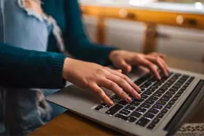 A student works on an assignment on her laptop