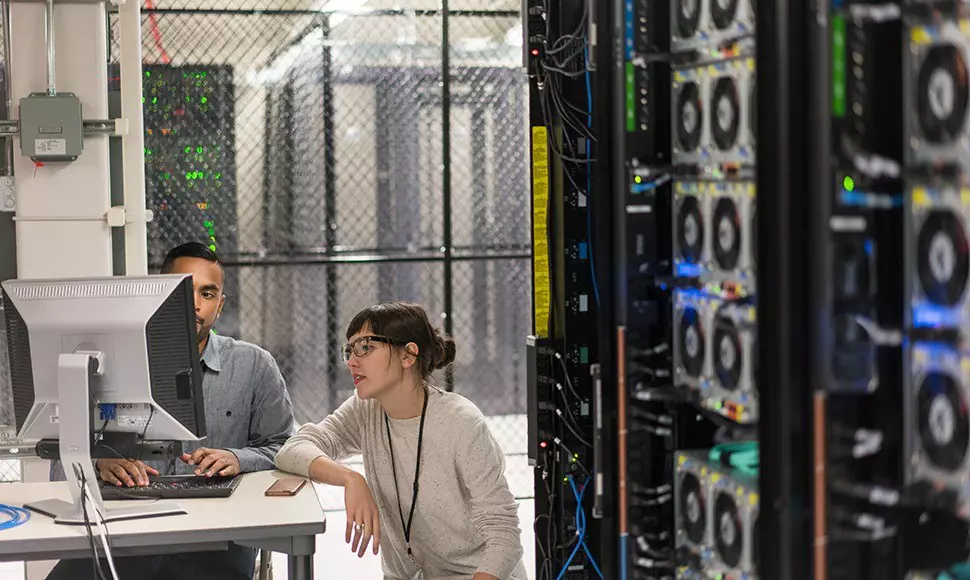 Two cybersecurity professionals working together in server room