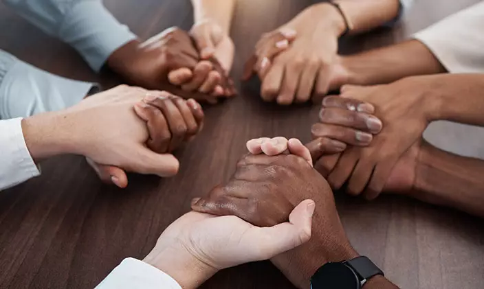 diverse group of people holding hands