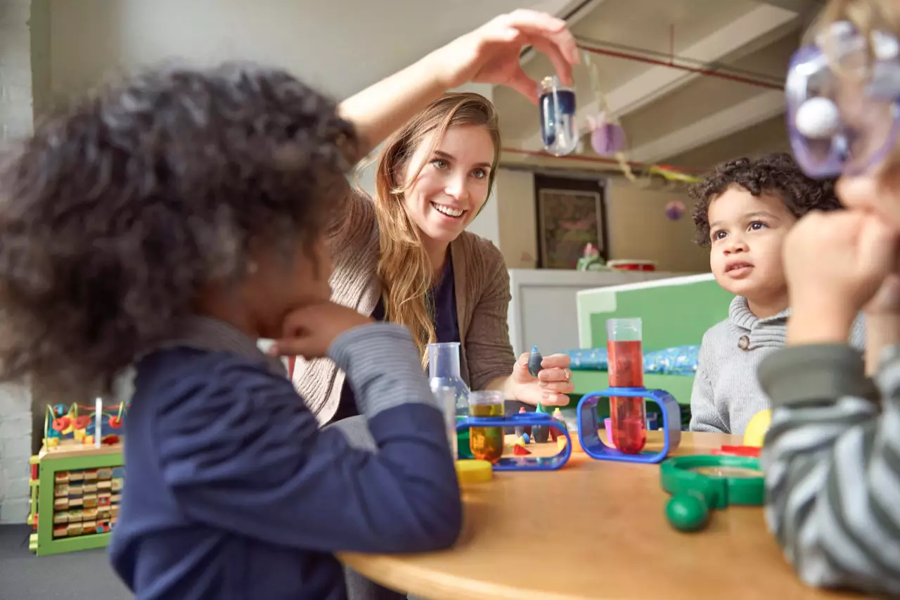 An early childhood education professional leads a group of children in a science activity