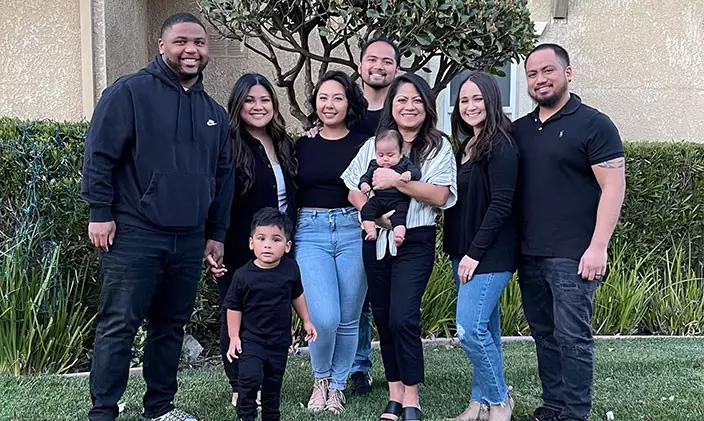 Emely Arienza and family smiling in front of house