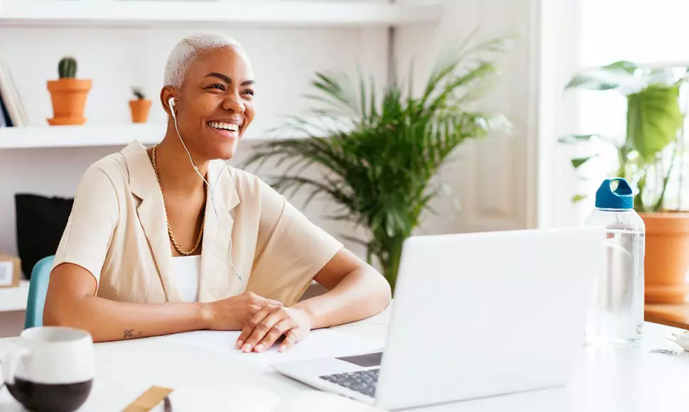 Experienced worker smiling in front of a laptop