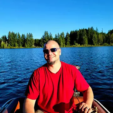 Joshua Grove smiling in boat on a lake