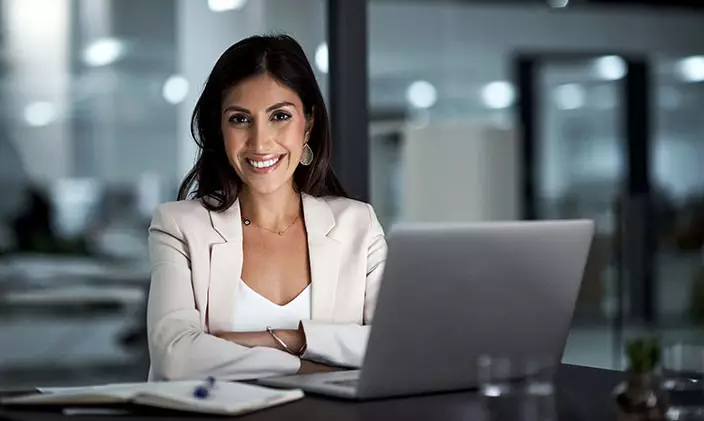 Hispanic female professional sitting beside laptop