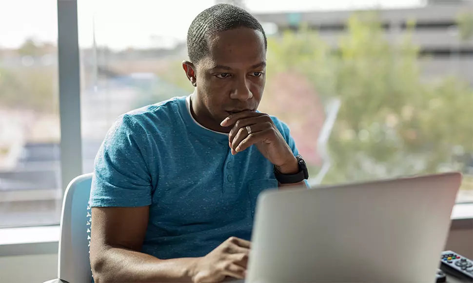 Man on laptop, researching IT