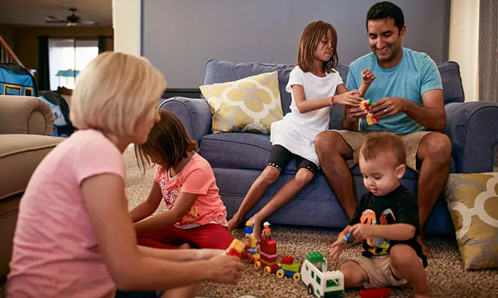 adults playing with small children on the floor