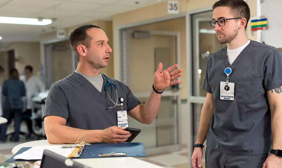 Male nurses discuss a patient