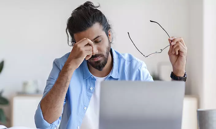 Tired man in front of laptop