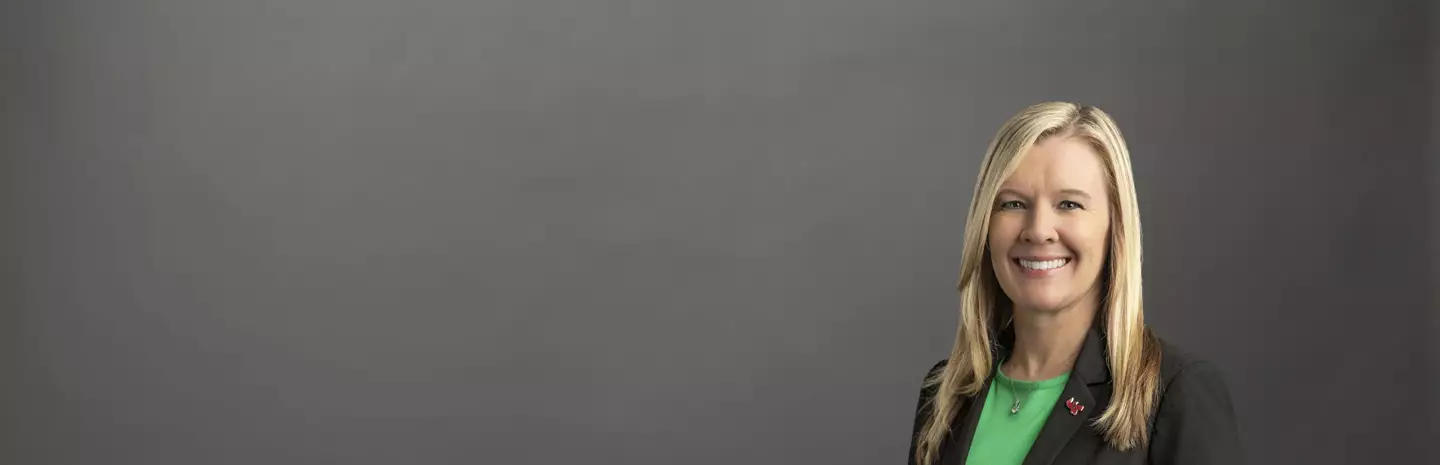 Associate Provost, Colleges, Christina Neider wearing a black suit jacket and green blouse.