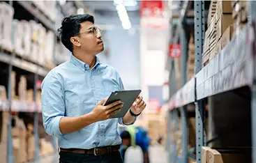 An operations manager checks inventory in a warehouse setting