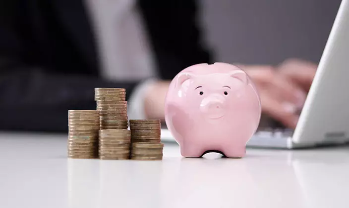 Piggy bank next to a pile of coins