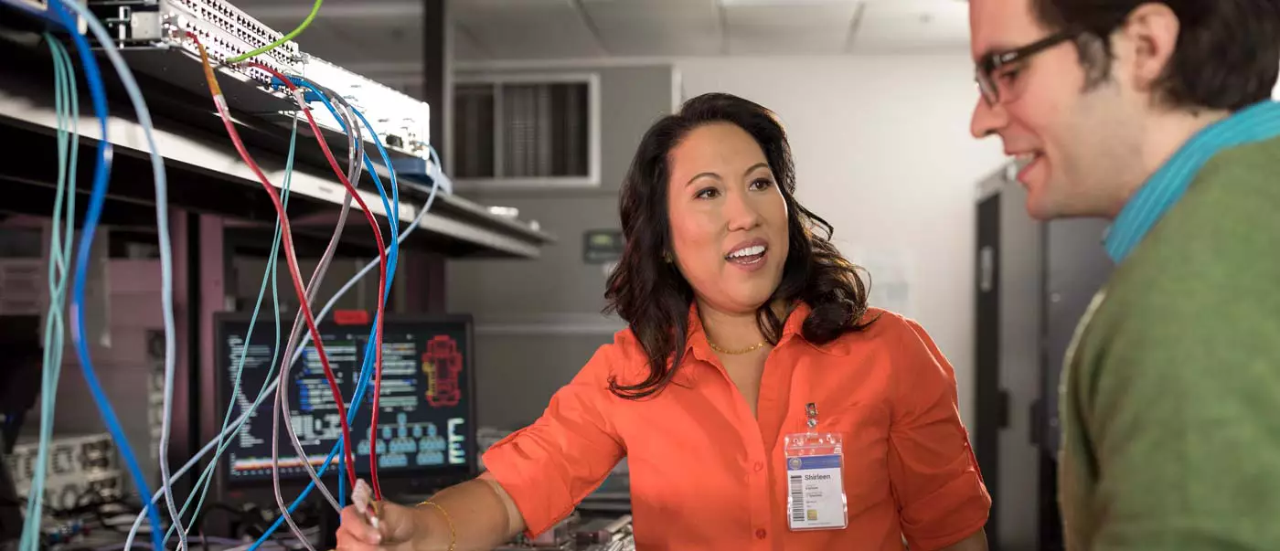 Two colleagues converse in the server room