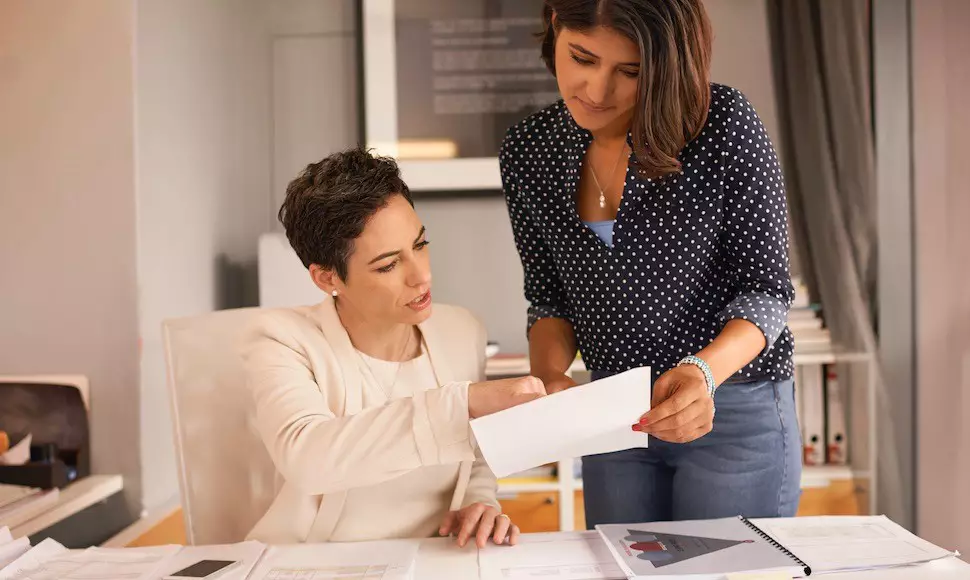 Colleagues look over a report together