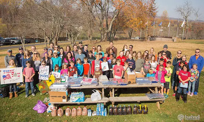 Veterans, family and staff gather outside at the Willing Warriors retreat