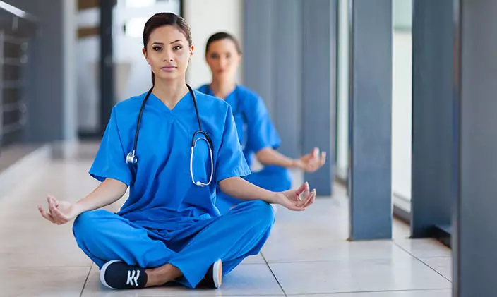 Image of nurses in a meditation pose as a way to combat healthcare burnout