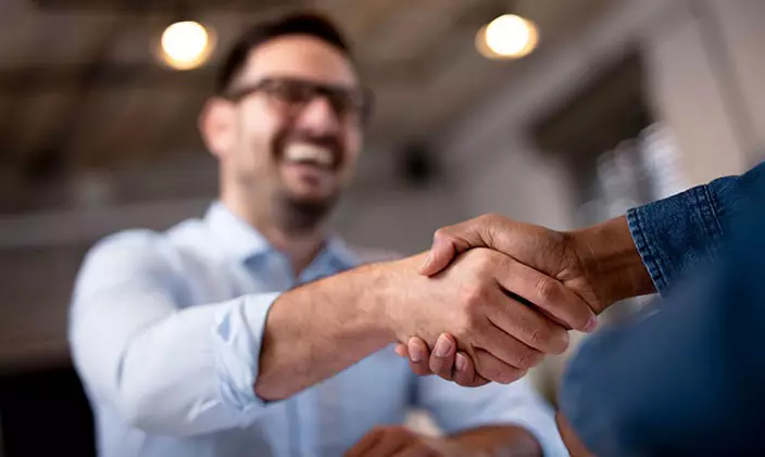 A business man shaking hands with another