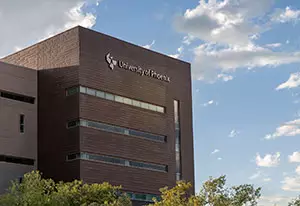 Link to an image of the ¼ϲʿ building in front of a blue sky with light clouds, with the building in the lower left portion of the frame