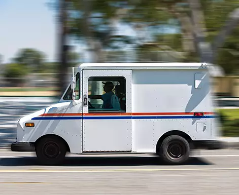 A USPS mail truck makes its rounds