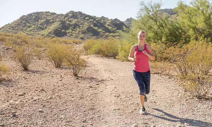 Woman running along a path in the desert