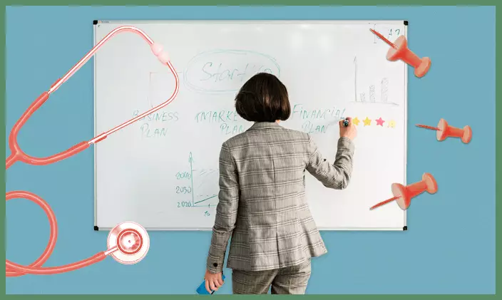A female health services manager business woman writing on a white board