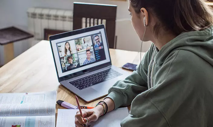 A student participates in a remote class via her laptop