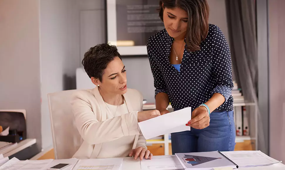 Two business women looking over business paper